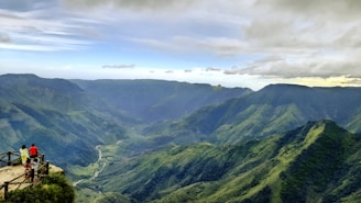 a couple of people standing on top of a mountain