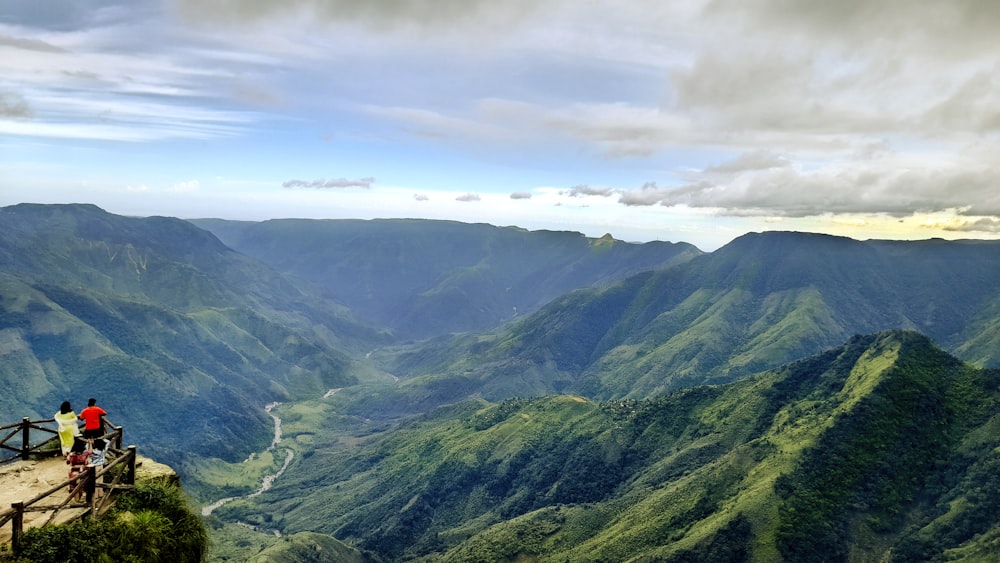 a couple of people standing on top of a mountain