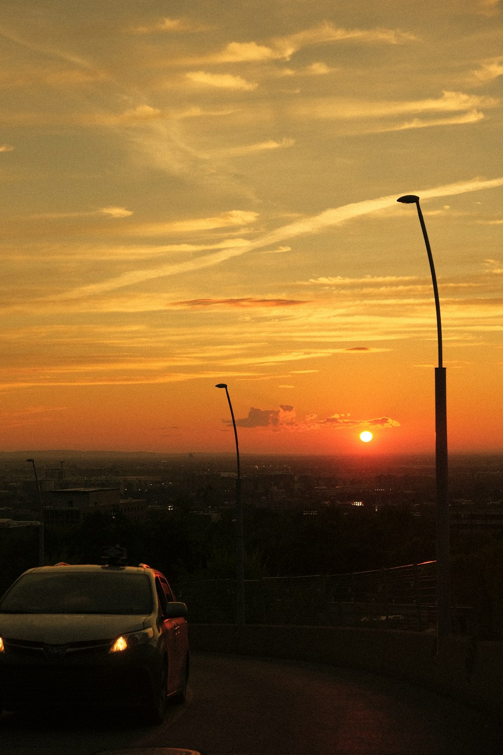 a car driving down a road at sunset