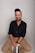 a man sitting on a stool with his legs crossed
