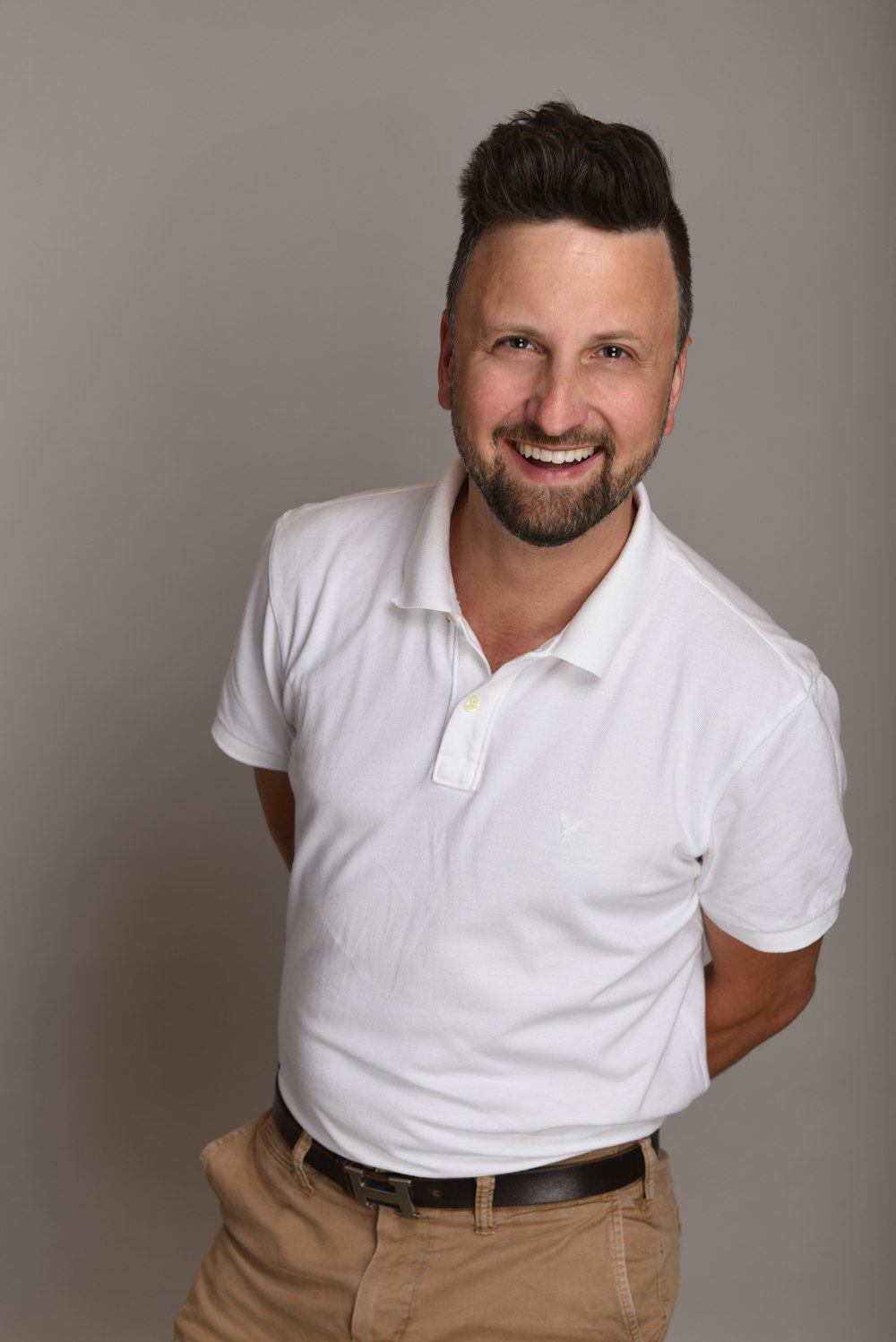 a man in a white shirt and tan pants