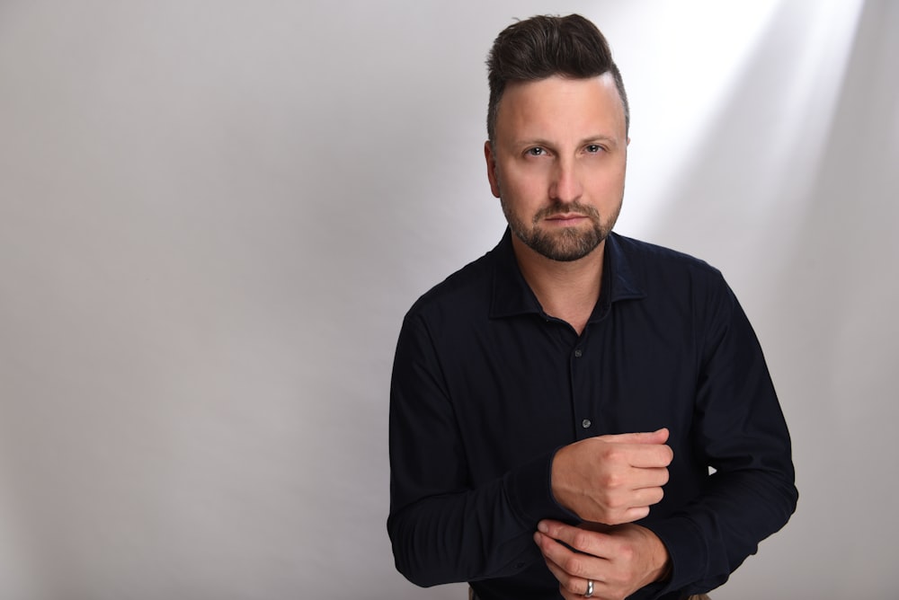 a man in a black shirt is posing for a picture