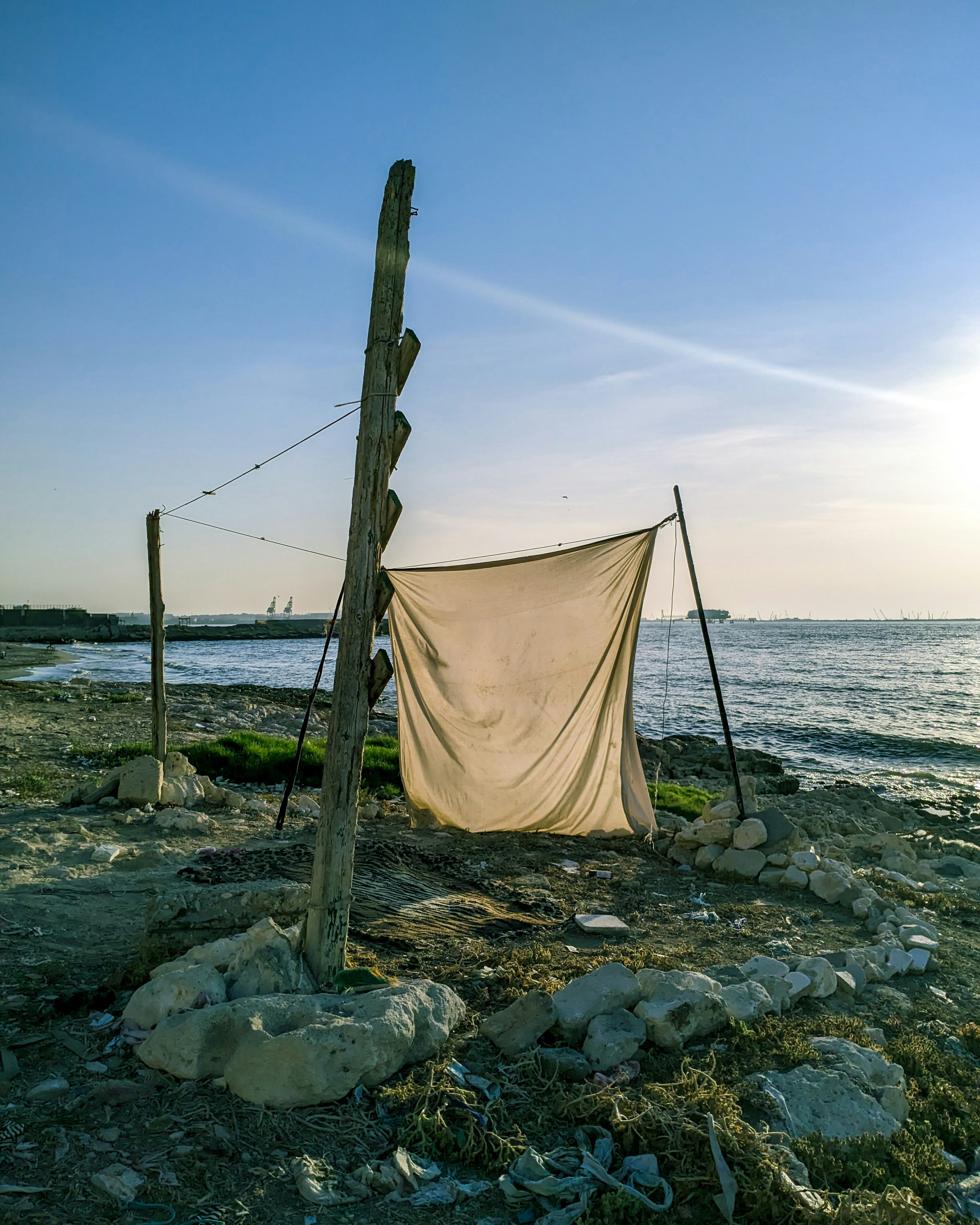 eine Wäscheleine an einem felsigen Strand neben einem Gewässer