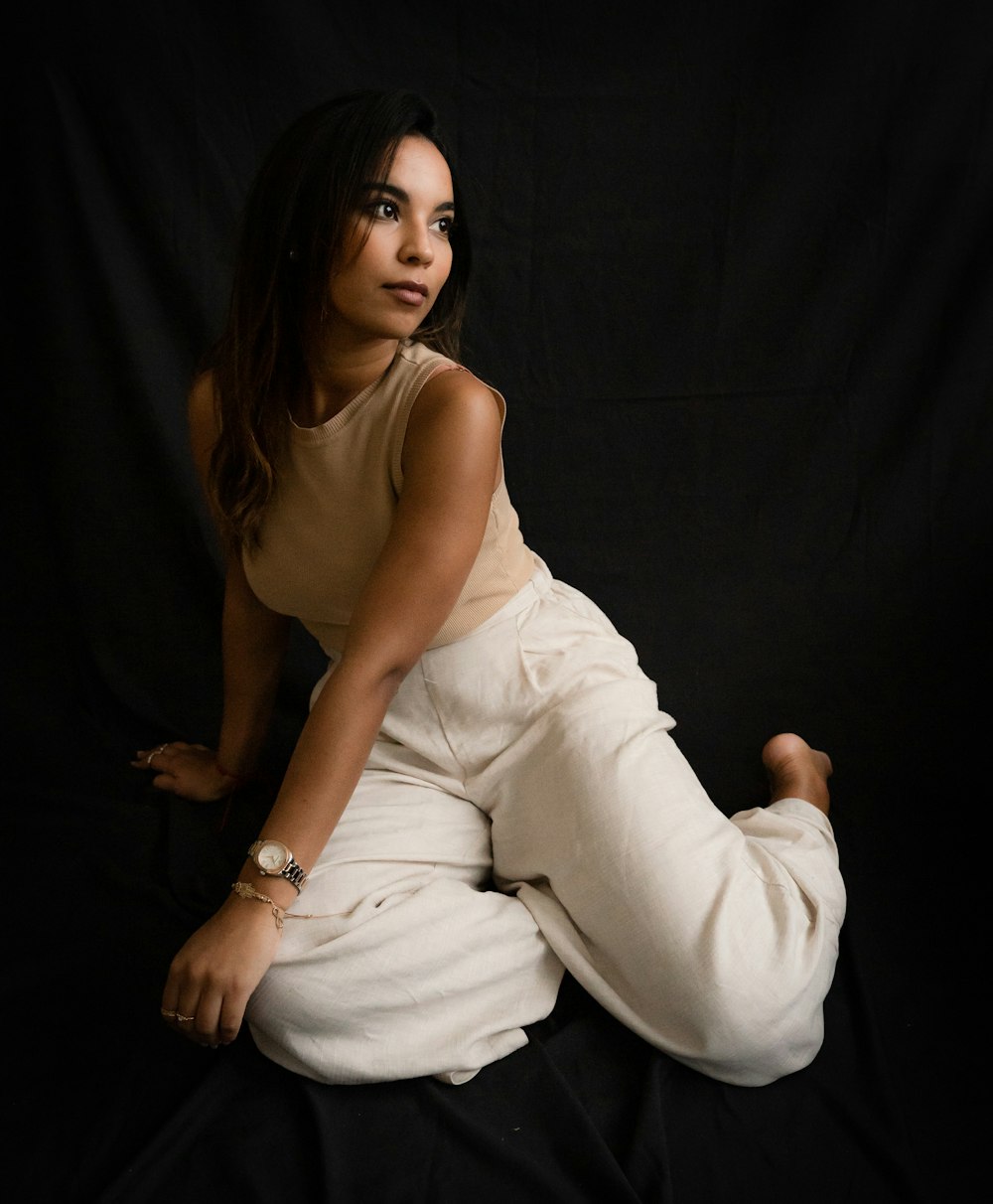 a woman sitting on the ground in a white dress