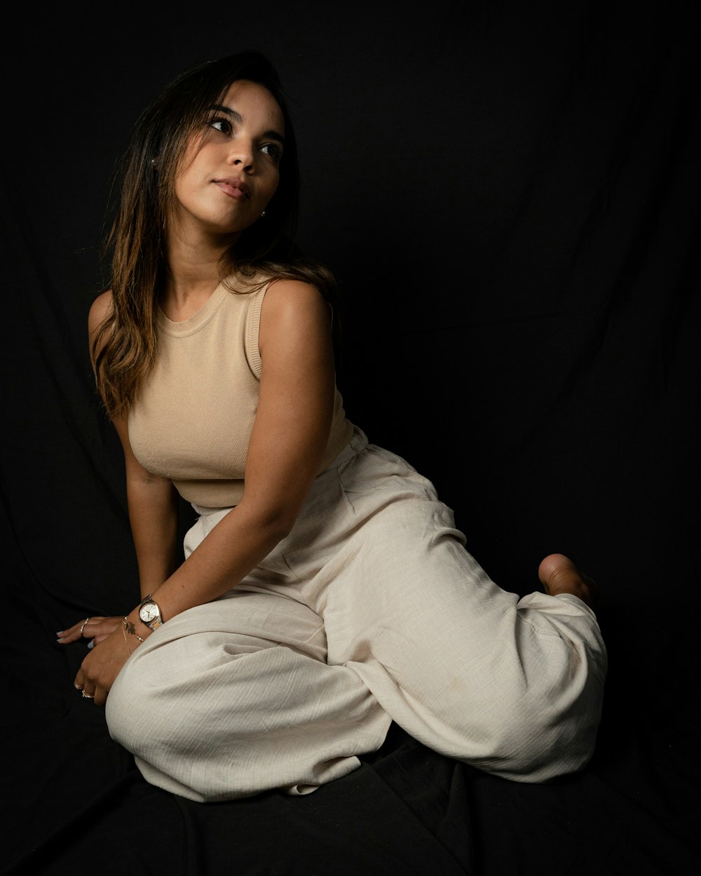 a woman sitting on a black background posing for a picture