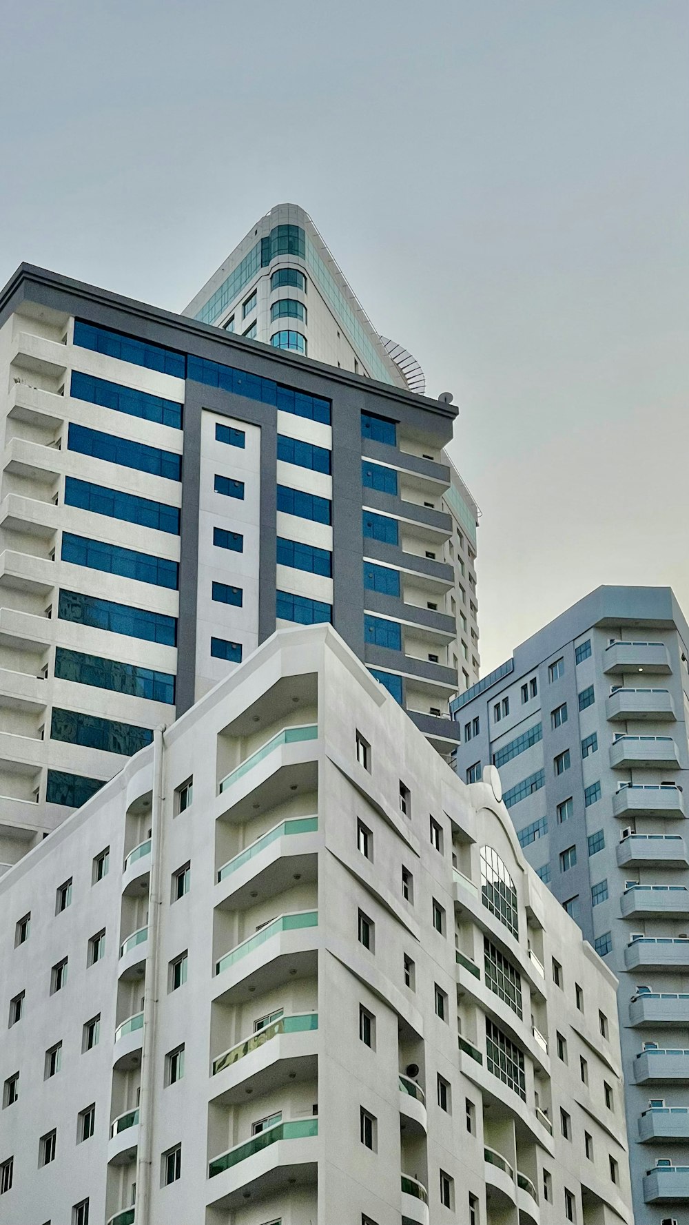 a very tall white building next to some very tall buildings