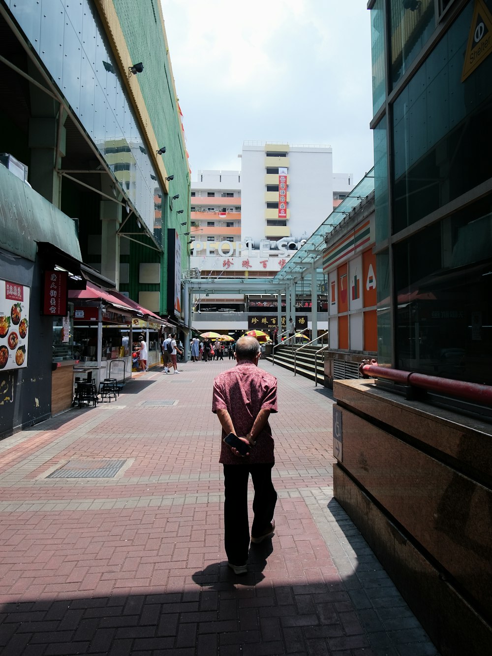 a man walking down a sidewalk in a city