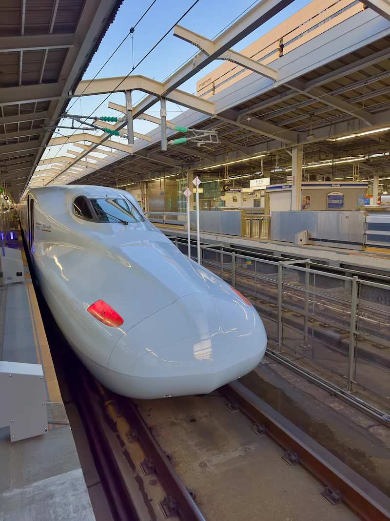 A Shinkansen in JR West / JR Kyushu livery standing at Shin-Osaka Station