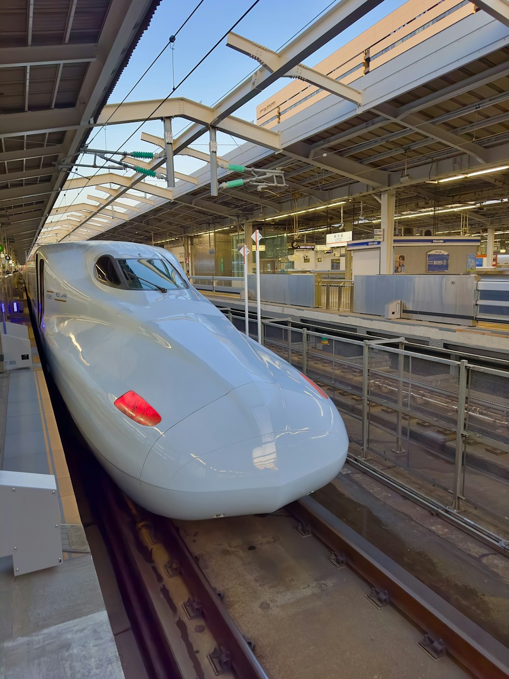 a white bullet train pulling into a train station