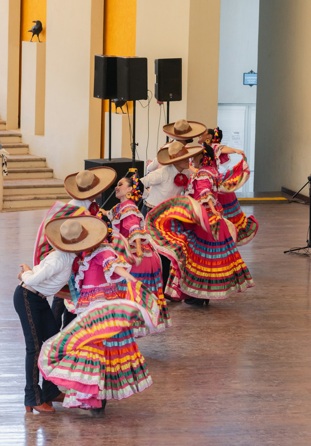 a group of women in colorful dresses and hats