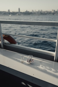 A serene luxury boat deck with neatly arranged notebooks and a steaming cup of tea, bathed in soft natural light.