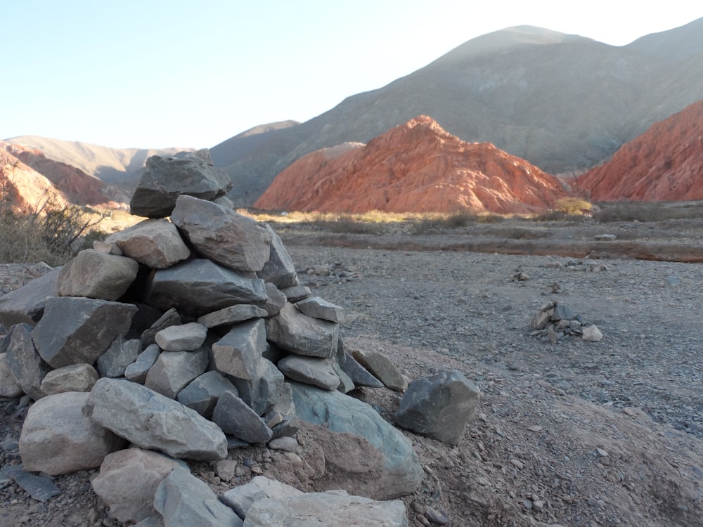 un mucchio di rocce seduto in cima a un campo sterrato