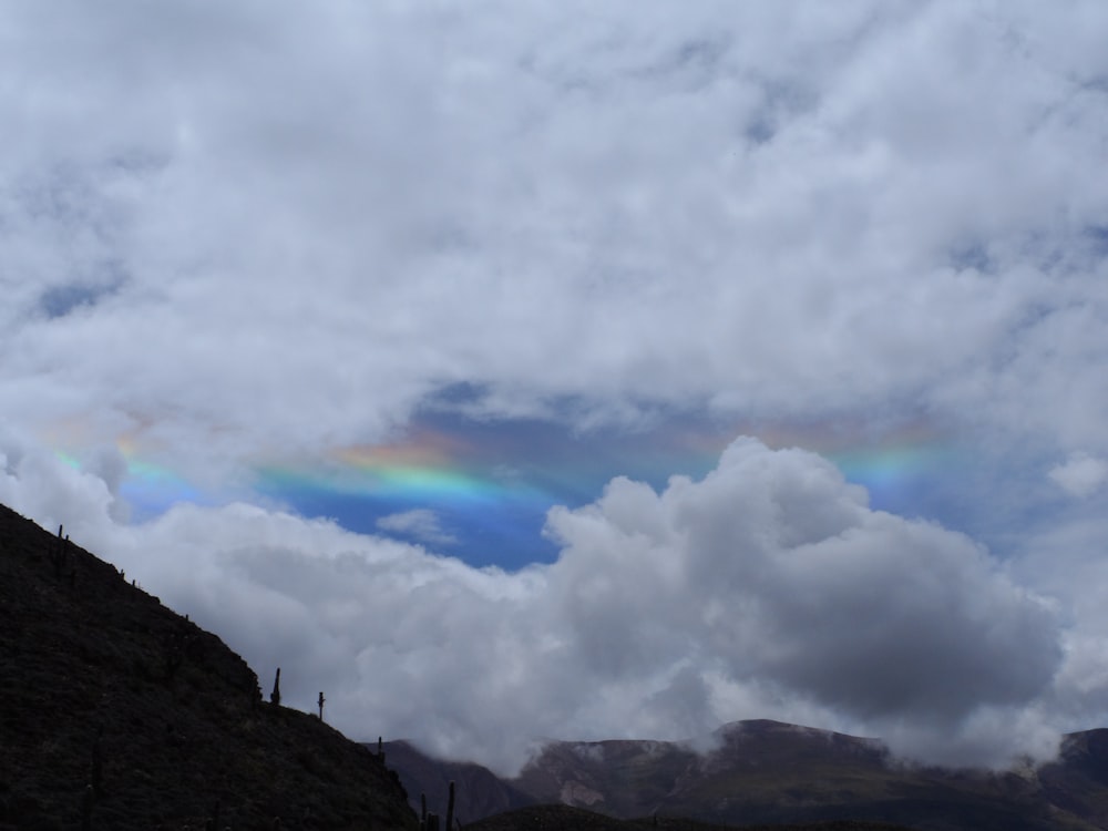 a rainbow in the sky over a mountain