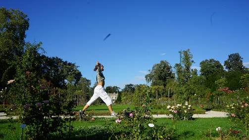 a man is doing yoga in a garden