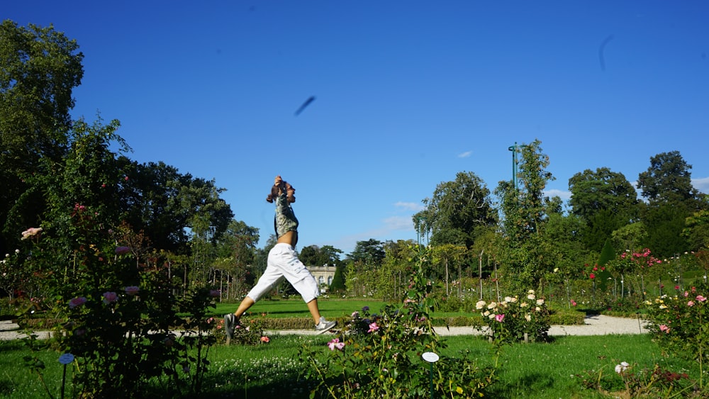 a man is doing yoga in a garden