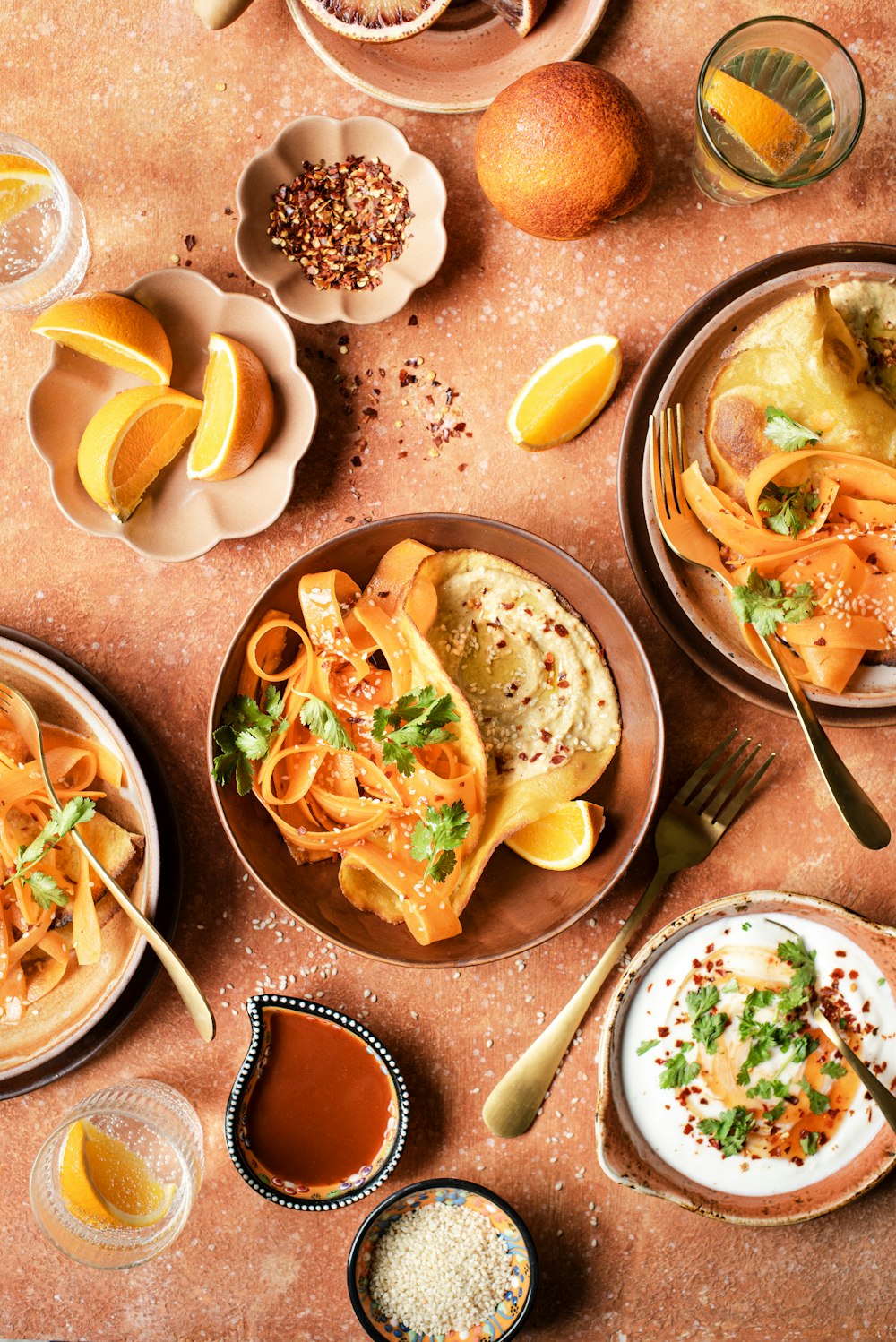 a table topped with plates of food and bowls of sauce