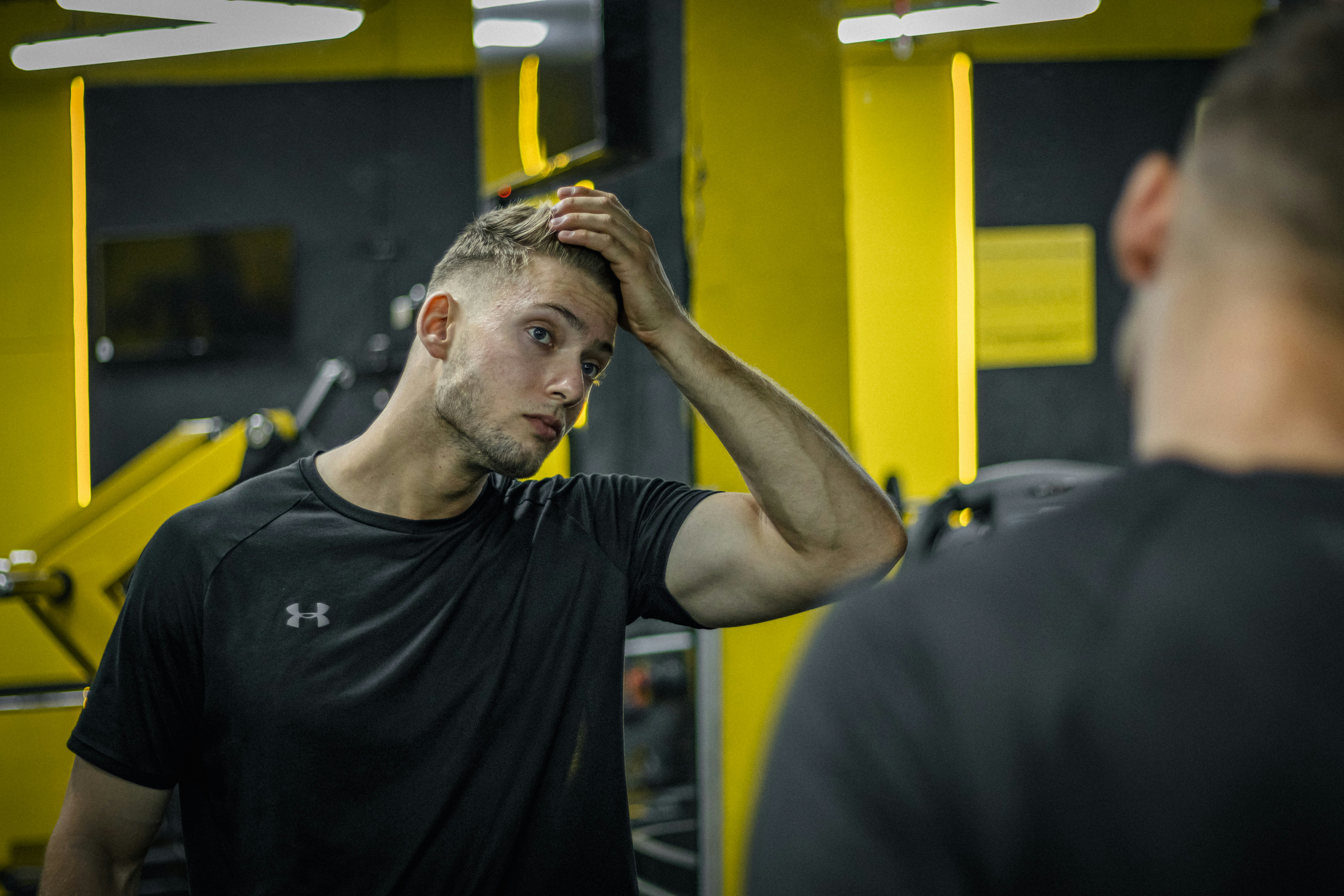 Athlete in gym looking at reflection while building mental strength and confidence