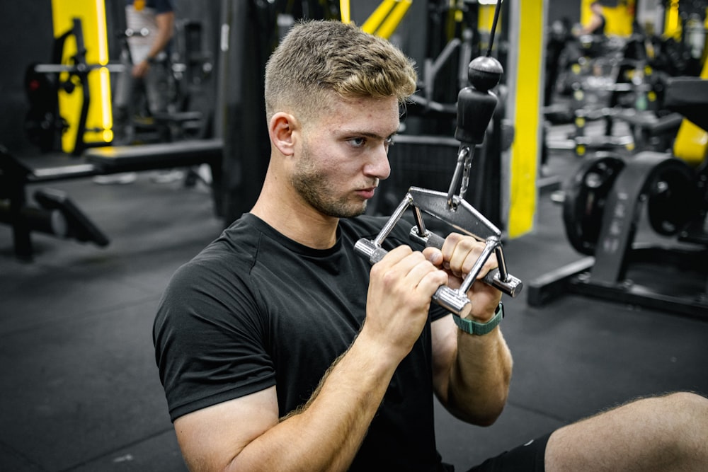 a man holding a machine in a gym
