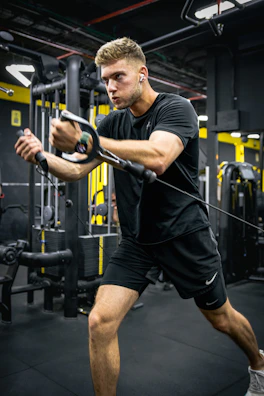 A fitness trainer guiding a client through a focused exercise in a modern gym.