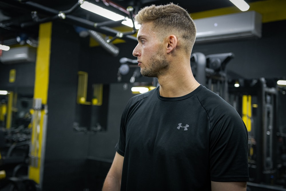 a man standing in a gym looking off into the distance