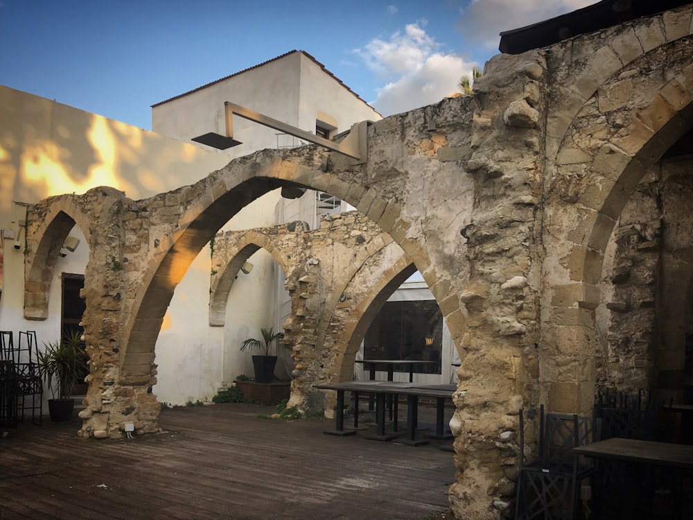 an old stone building with arches and benches