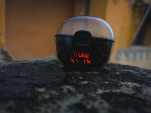 Vibetech wireless earbuds resting on a modern concrete bench with city skyline blurred in background.