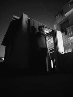 a sharp black-and-white photo of a detective on stakeout at night