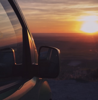 the sun is setting in the distance behind a truck