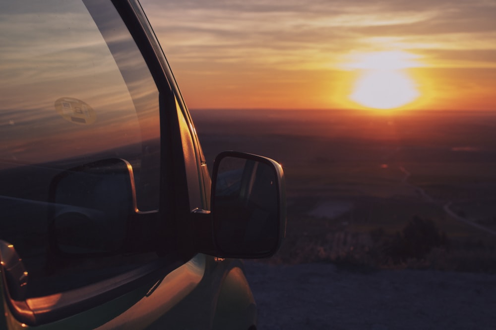 the sun is setting in the distance behind a truck