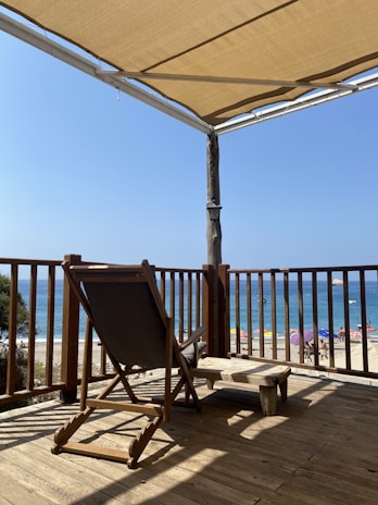 Outdoor deck with lounge chairs and a view of the nearby sandy beach.
