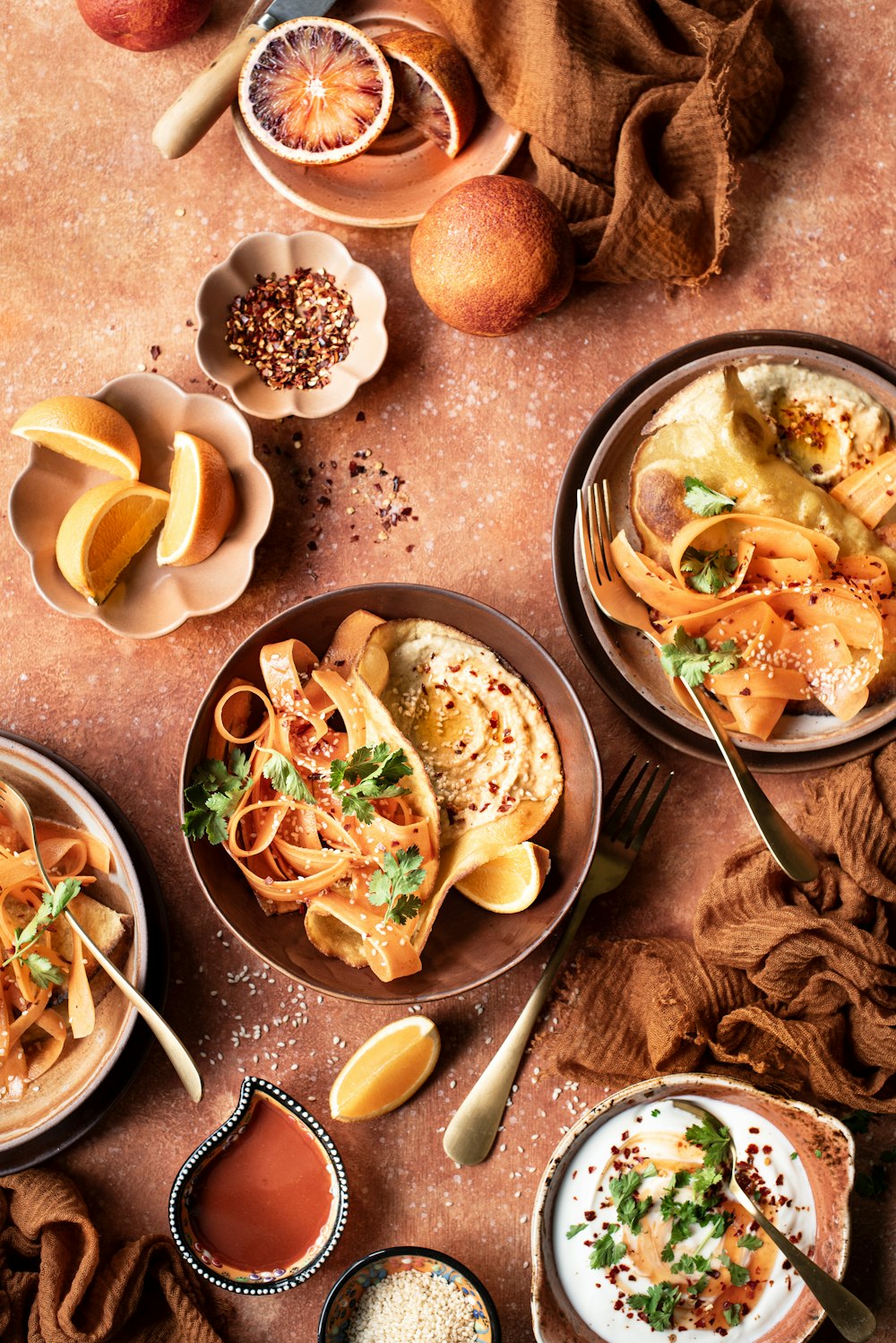 a table topped with bowls of food and bowls of sauce