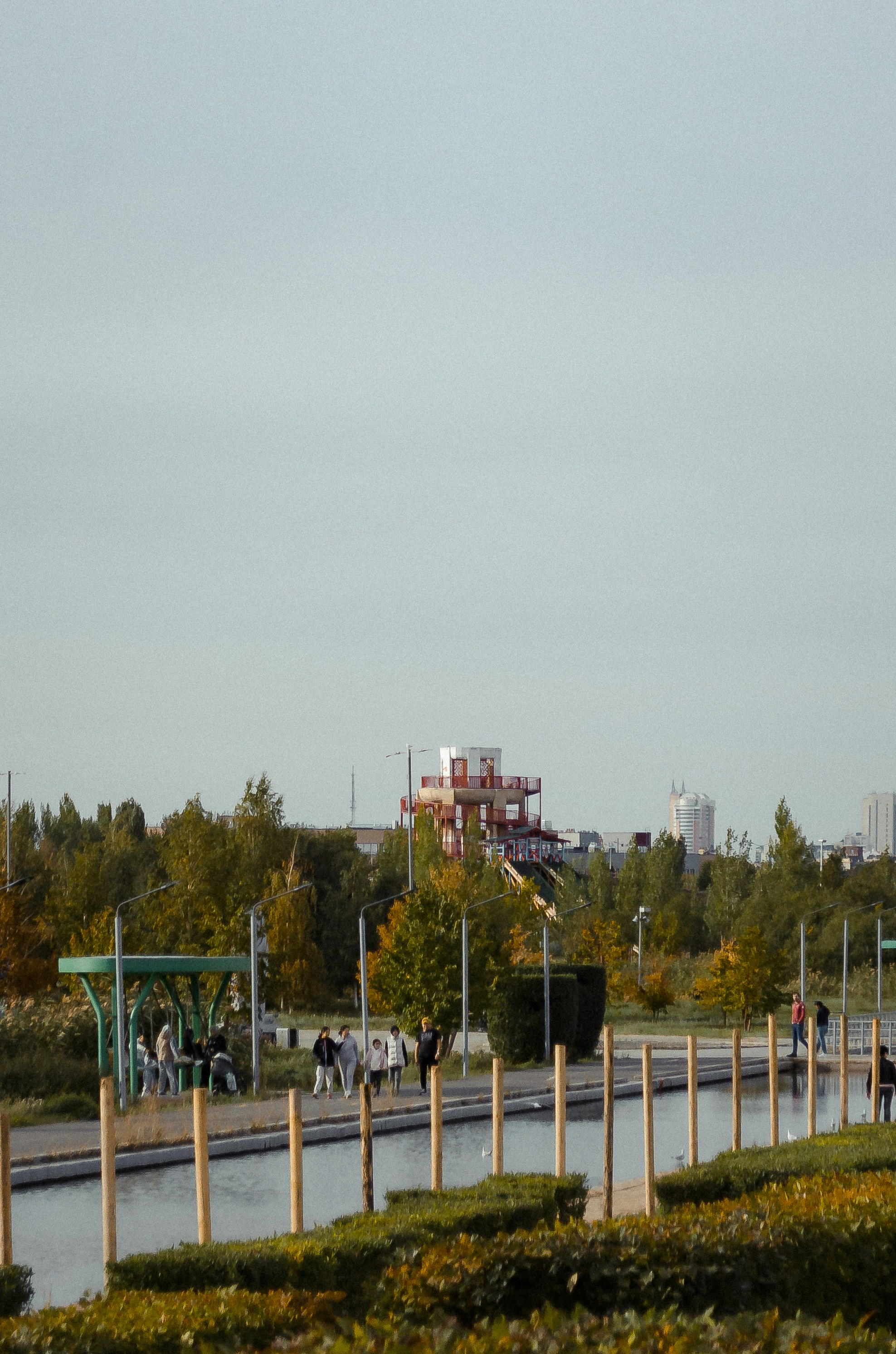 a group of people walking down a street next to a river