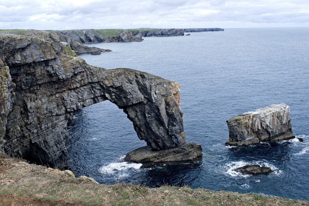 a large rock formation in the middle of a body of water