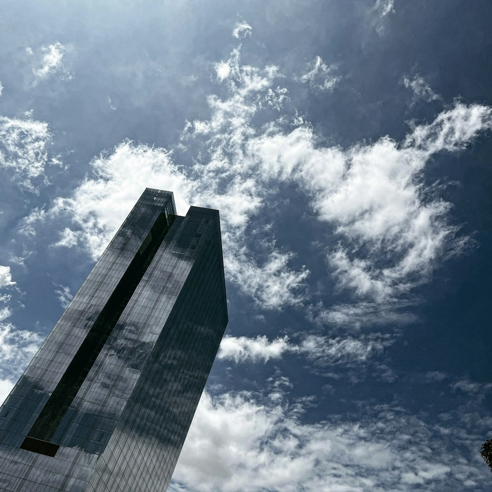 a tall building sitting under a cloudy blue sky