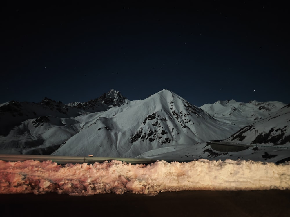 a night time view of a snowy mountain range