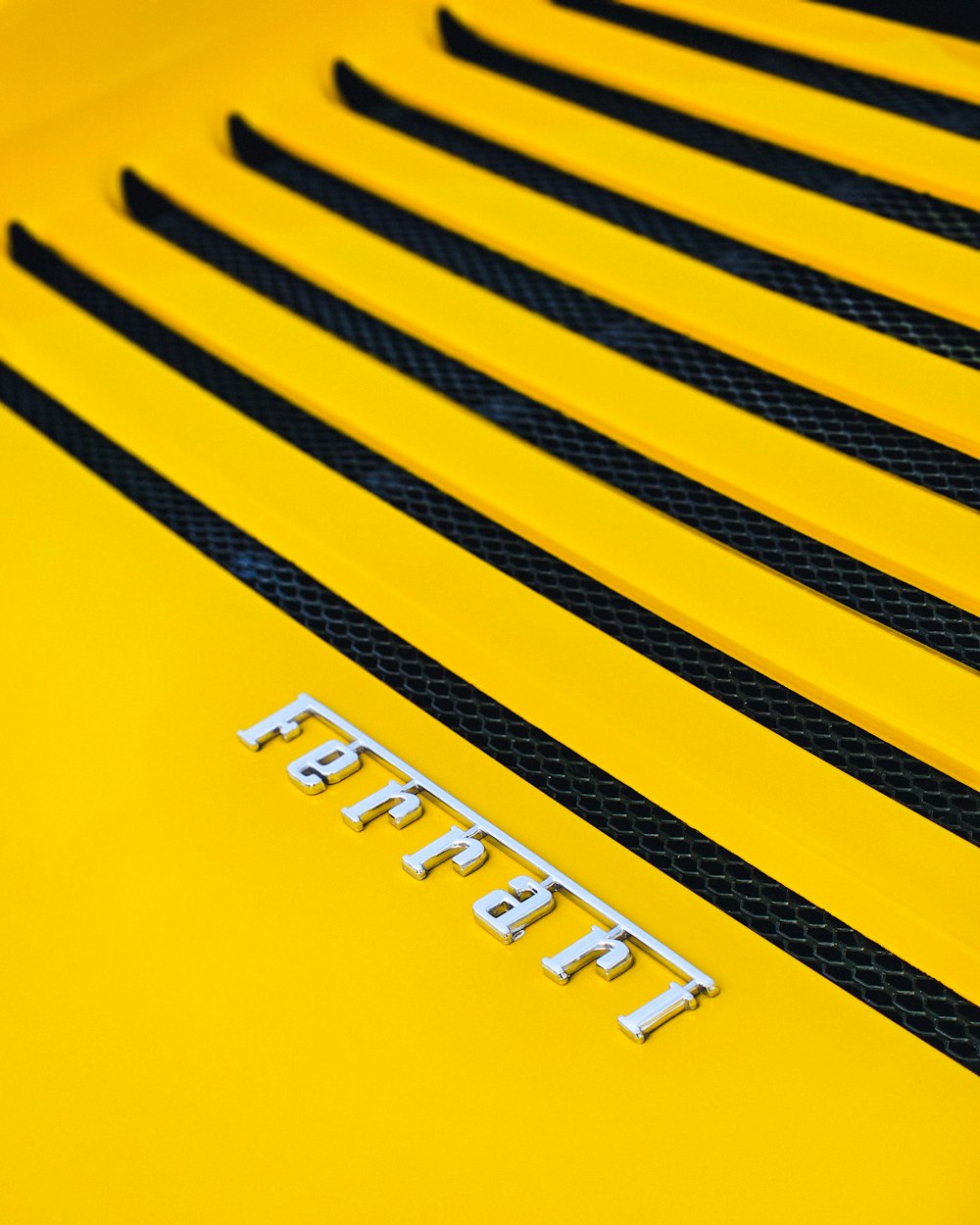 a close up of the hood of a yellow sports car