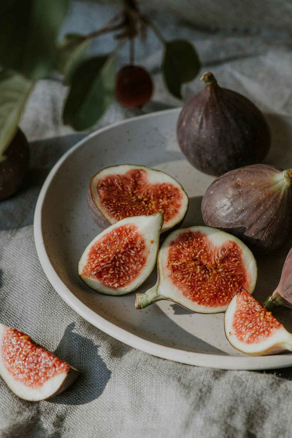 a white plate topped with figs on top of a table