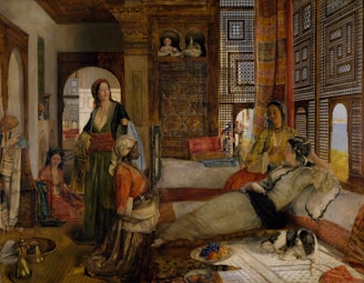 A richly decorated interior featuring several women in traditional attire, relaxed and conversing in an opulent, Eastern-style room. Intricate wooden lattice work and vibrant textiles adorn the room, and a small dog rests peacefully on a carpet. A fruit platter and vases of flowers add to the luxurious atmosphere.