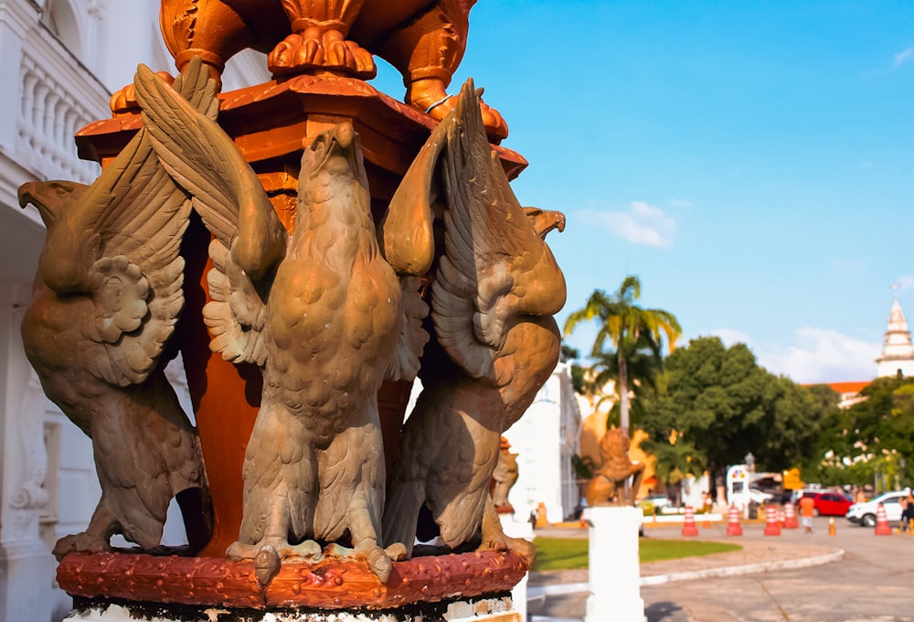 uma estátua de três pássaros no topo de um pilar