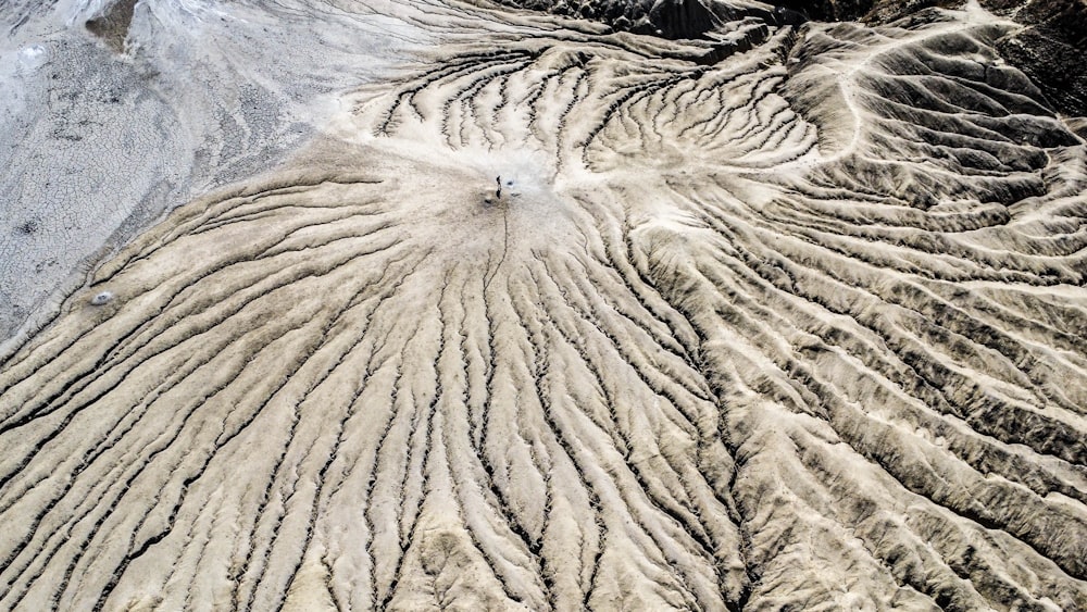 an aerial view of a mountain range with snow on the ground