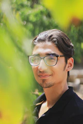 a man wearing glasses and a black shirt