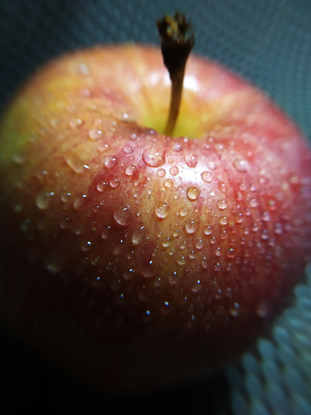 une pomme rouge avec des gouttelettes d’eau dessus