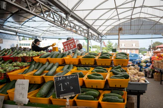 Baskets filled with crisp green zucchinis neatly arranged at the market stall.
