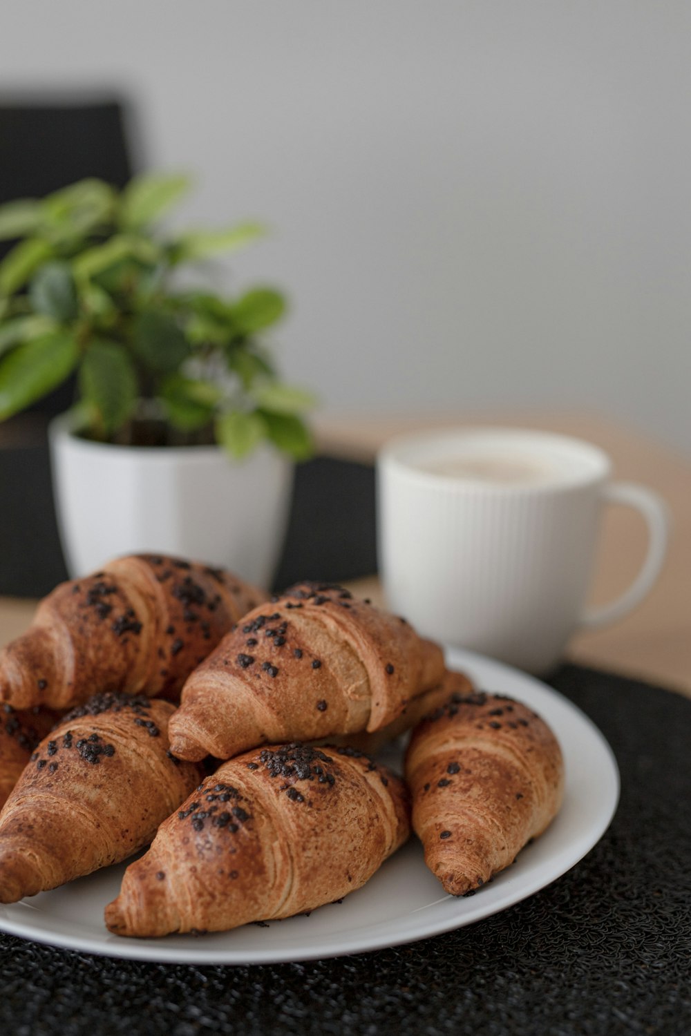 a white plate topped with croissants next to a cup of coffee