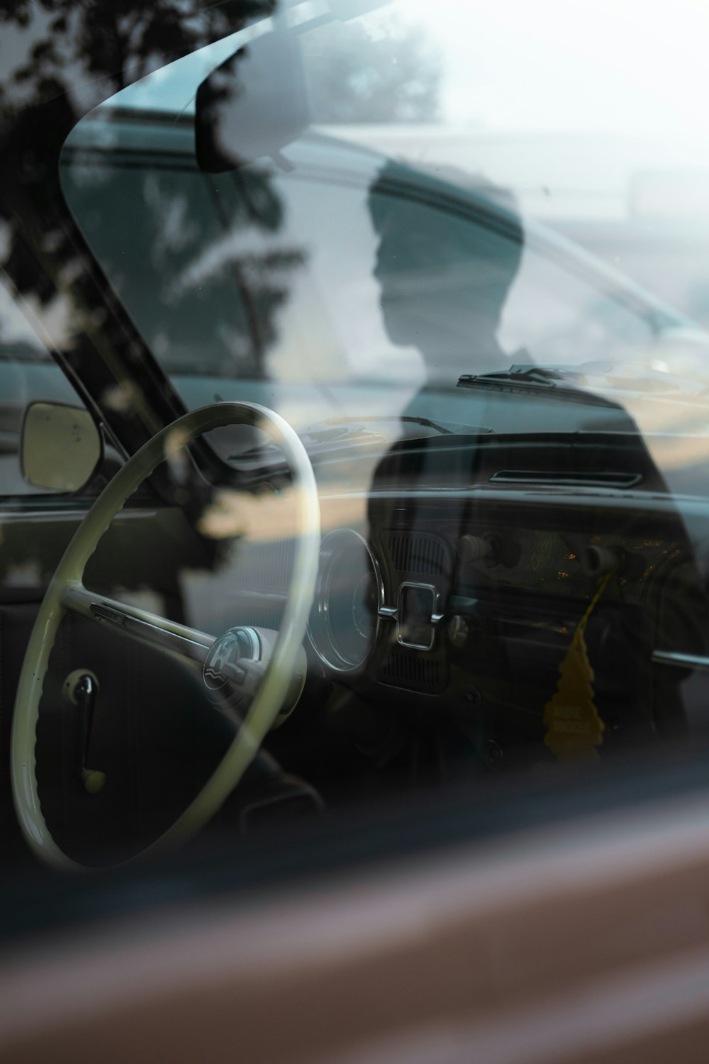 a reflection of a man sitting in a car