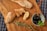 Close-up of a rustic Mediterranean meal featuring olives, bread, and cheese on a wooden table.