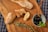 Close-up of a rustic Mediterranean meal featuring olives, bread, and cheese on a wooden table.