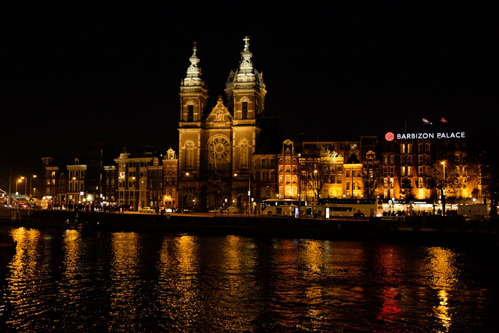 a large cathedral lit up at night by the water