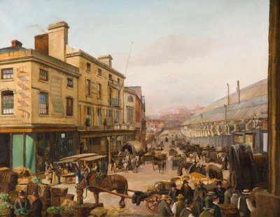 A bustling 19th-century market scene with horse-drawn carriages, numerous vendors, and shoppers in an open-air market setting. The architecture includes multi-story buildings with signs advertising various businesses. People are gathered around stalls filled with goods like fruits and vegetables. The scene captures the busy atmosphere of a marketplace.