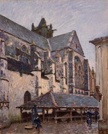 An impressionist painting depicts a large, old stone building, possibly a church or cathedral, with detailed architectural features like arches and spires. The setting appears to be a rainy day, as indicated by the wet appearance of the ground and people carrying umbrellas. A covered wooden structure sits in front, with a few figures moving around in the scene.